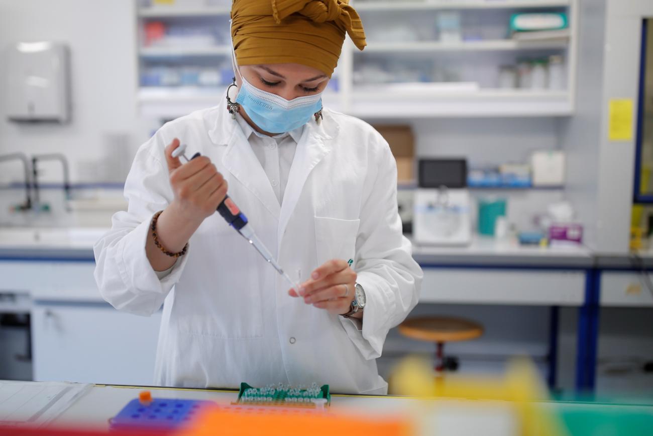A researcher manipulates proteins in a laboratory as part of a project to develop a COVID nasal spray vaccine.