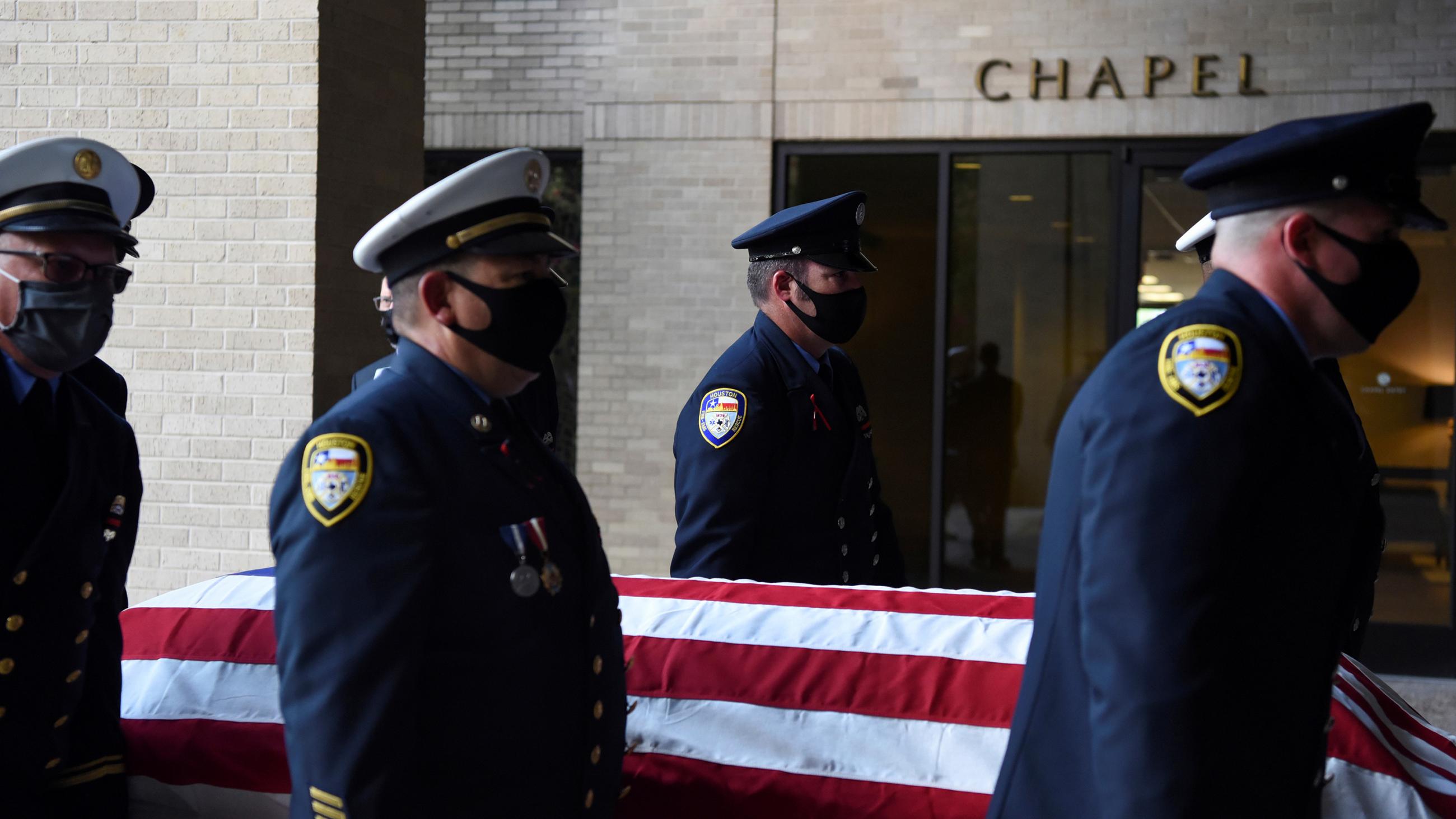 The photo shows a firefighter honor guard carrying a casket.