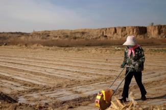 A worker uses a planter to plant corn seed in a village near the edge of the Gobi Desert, on the outskirts of Wuwei, Gansu province, China, on April 14, 2021.
