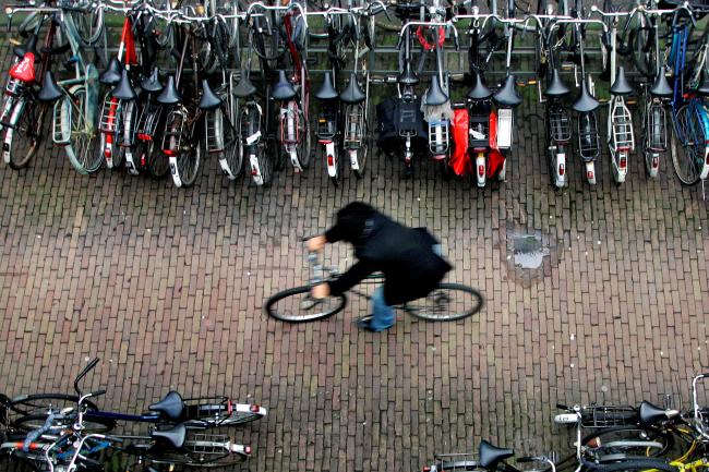 A man rides his bike in a bicycle shed near Central Station Amsterdam January 17, 2007. There are more bicycles than people in the Netherlands, where each resident clocks up an average of 917 kilometers (573 miles) a year on two wheels.